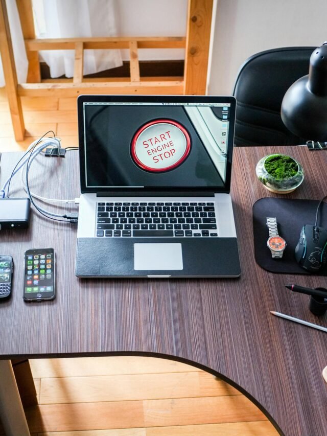 A contemporary office desk setup with laptops, gadgets, and accessories, creating a tech-savvy workplace.