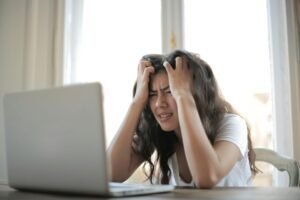 Frustrated woman struggling with remote work stress and scratching her head