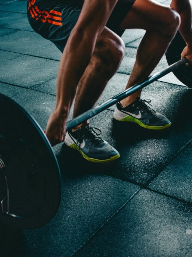 Man performing a deadlift exercise in a gym, demonstrating strength and fitness.
